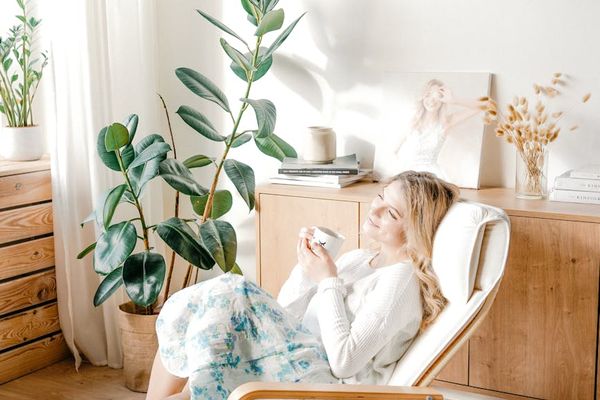 Person sitting calmly in a bright, minimalist room.